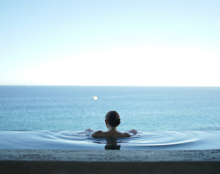 woman in a pool overlooking the ocean