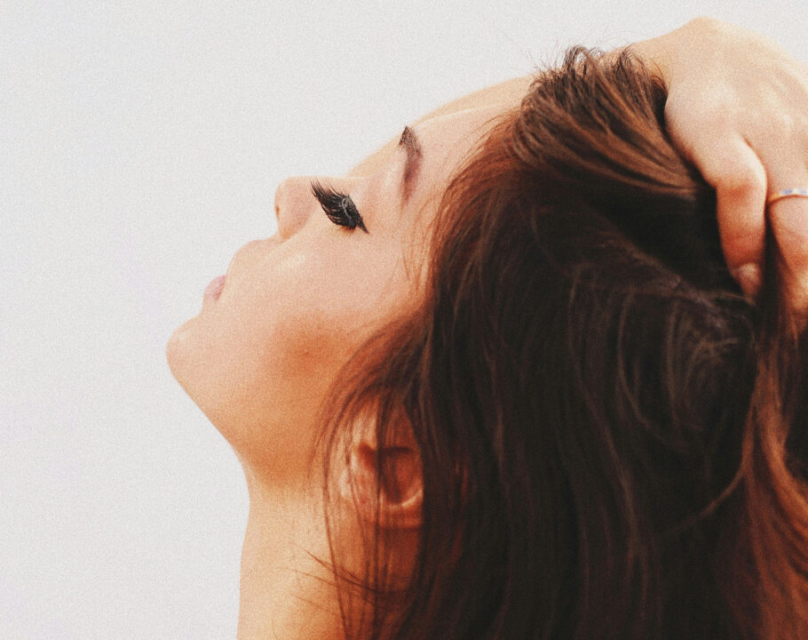 woman looking up touching hair