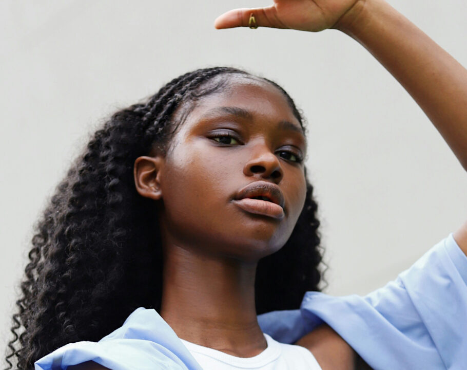 a woman in a white top and a blue jacket raising arms